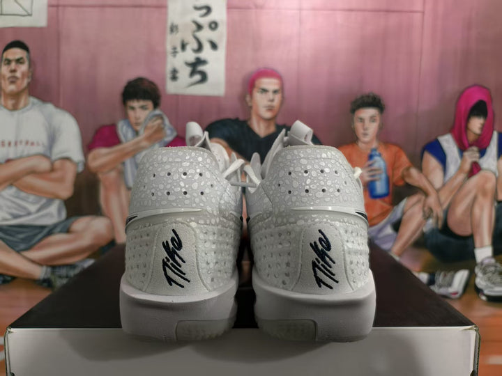 Rear view of white Nike sneakers with perforated heel panels, black heel branding, and red accents visible at the sides.