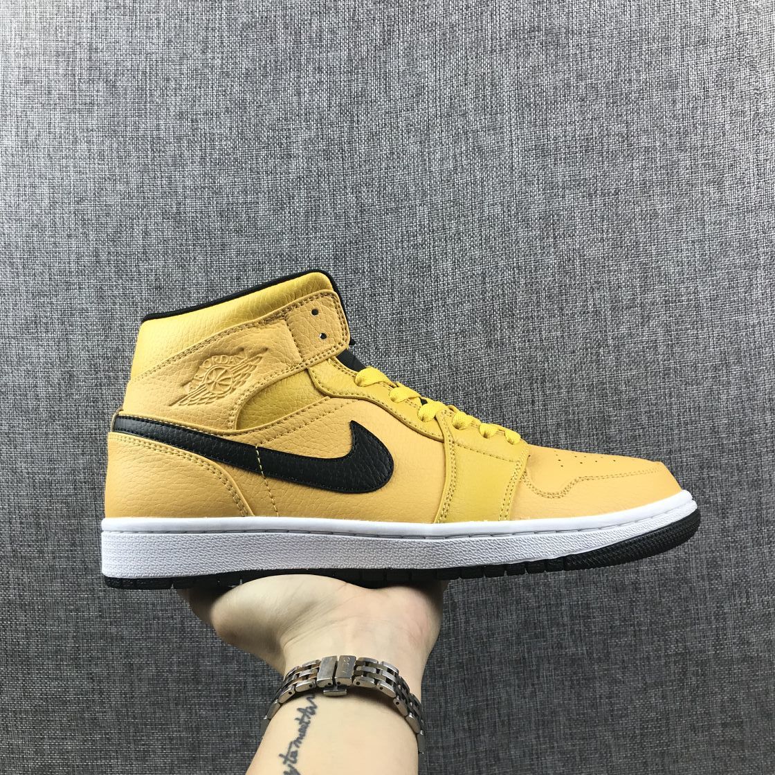 Side profile of a yellow Air Jordan 1 Mid sneaker with a black Swoosh, white midsole, and black outsole.