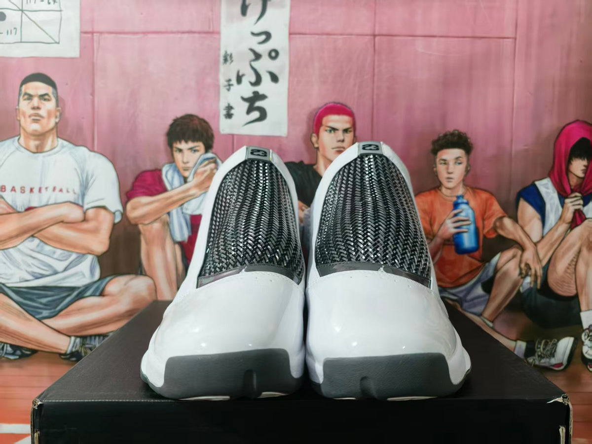 Pair of white and gray high-top basketball sneakers viewed from the front, showing black textured-look panels and dark toe accents.