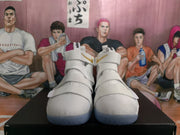 Front view of a pair of white high-top basketball sneakers with multiple adjustable straps and textured uppers.