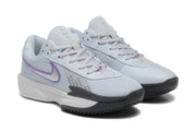 Pair of pale grey Nike tennis shoes with purple Swoosh accents, shown at an angle