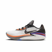 White Nike GT Cut 2 sneaker with an orange forefoot accent, patterned dark Swoosh, and purple heel detail.