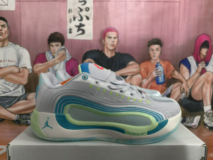 Side view of gray Jordan basketball sneakers with blue and green layered accents, displayed on a box.