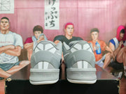 Rear view of the gray and white Nike sneakers showing heel panels, reflective-looking geometric details, and perforations near the midsoles.
