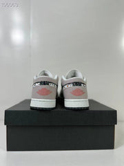 Rear view of the pink and sail low-top sneakers displayed on a black shoe box.