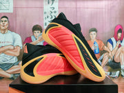 Angled view showing the coral-pink side panels, black upper and gold-toned overlays.