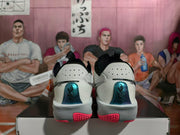 Rear view showing metallic blue heel panels and pink outsole accents on white Nike Sabrina basketball shoes.