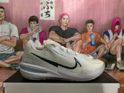Side profile of a white and silver Nike basketball shoe with a black Swoosh and layered sole.