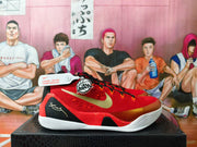 Red and gold Nike Kobe low-top basketball shoe shown from the side.