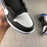 Close-up of the perforated white toe box framed by black overlays and a black lace area.