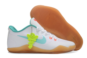 White and teal Kobe 11 shoe beside its gum-colored sole