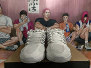 Front view of white Nike sneakers showing the lace-up construction, textured toe panels, and rounded outsole.