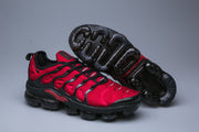 Red and black Nike TN sneaker with the segmented outsole visible.