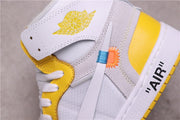 Close-up of the yellow winged Jordan logo, grey side panels, white Swoosh, and contrasting blue and orange stitching details.