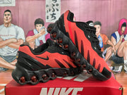 Angled view of the pair showing the black and red upper, side Swooshes, and rounded outsole elements.