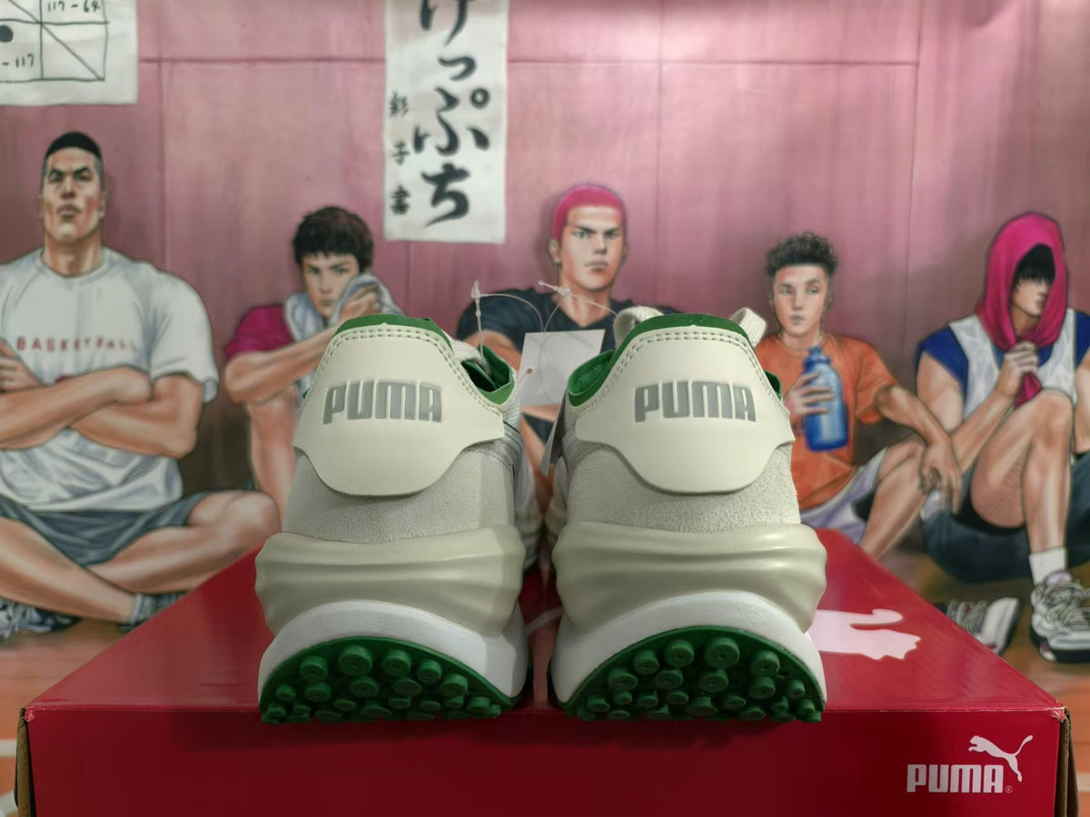 Rear view of off-white and green PUMA sneakers showing branded heel tabs and green outsoles.