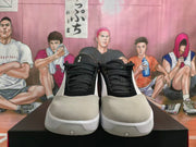 Front view of white, black, and light gray low-top basketball shoes