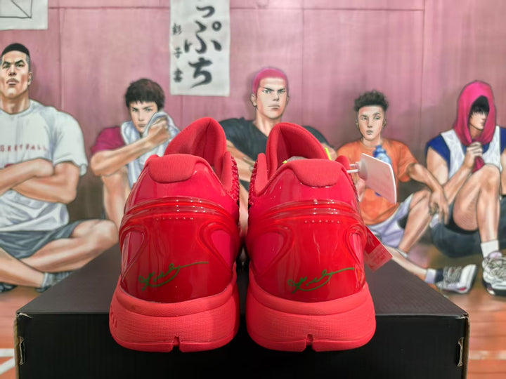 Rear view of red Nike basketball sneakers showing padded collars, glossy heel panels, and green heel detailing on a black box.