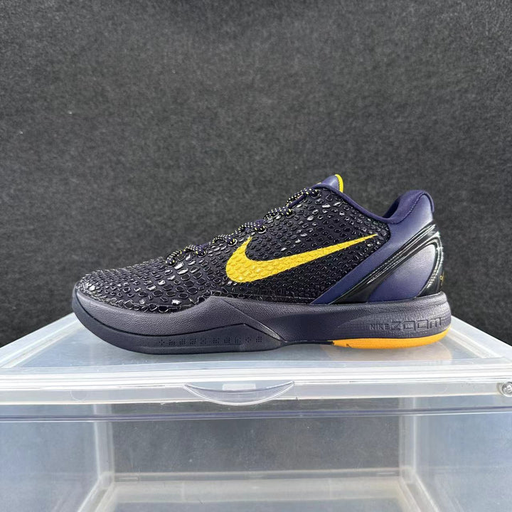 Side view of a low-top Nike basketball shoe in dark navy and purple tones with a yellow Swoosh and yellow outsole accents.