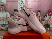 Angled view of pink Nike sneakers with black Swoosh logos and layered soles.