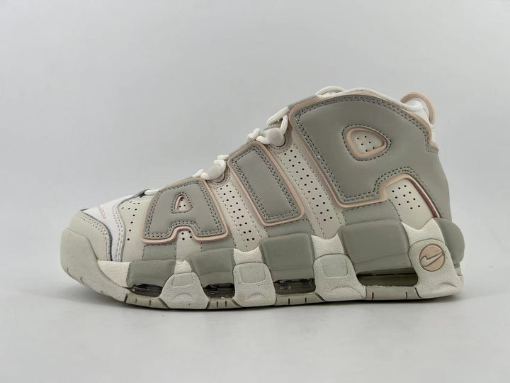 Side view of light neutral Nike Air More Uptempo high-top sneakers with oversized lettering and a segmented outsole
