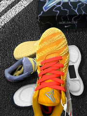 Close view of the yellow Nike basketball sneaker with red laces, patterned upper, and a blue shoe behind it.