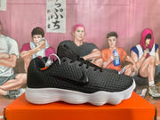 Side view of a black sneaker with a side logo and white ridged sole.