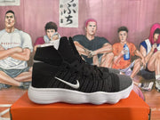 Side profile of a black high-top Nike sneaker with a gray toe, white Swoosh, and ridged white sole.