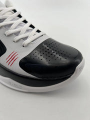 Close-up of the black perforated toe, white upper, and textured outsole edge