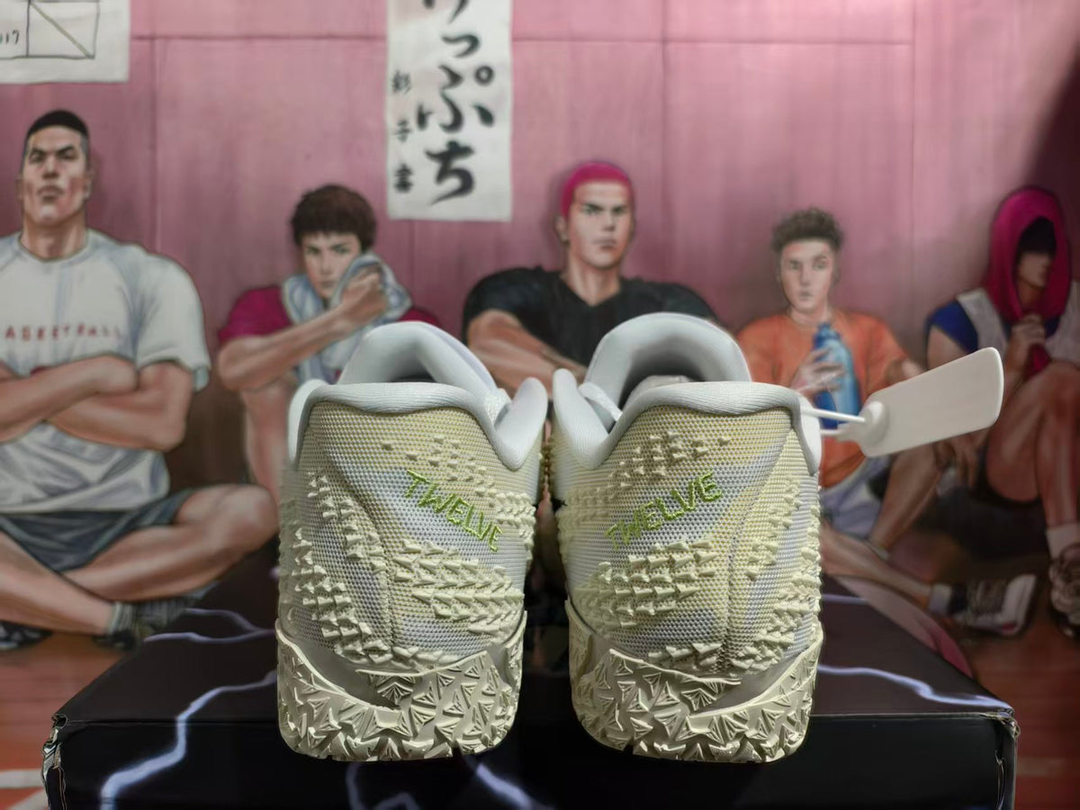 Rear view of white Nike Kyrie basketball shoes showing textured heels and pale green lettering.