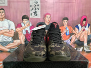 Front view of Nike basketball sneakers showing black laces, red tongue branding and a textured camouflage upper.