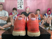 Rear view of coral-orange Nike Kobe basketball shoes with pink collars and light-colored soles.