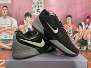 Angled view of the pair showing the black and grey colorway, side swoosh details, lace-up construction, and rubber outsoles.