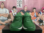 Front view of the green Nike sneakers showing the laces, textured toe areas, and yellow tongue details.