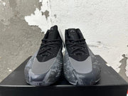 Front view of black and grey high-top Adidas basketball shoes with lace-up fronts and grey toe overlays.