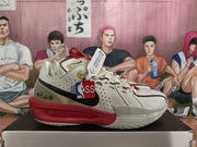 Side profile of a white Nike basketball sneaker with black Swoosh, red midsole detailing, perforated panels, and hangtags.