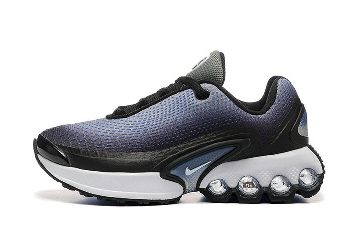 Side view of a blue, black, and white Nike kids’ sneaker with a patterned upper and pod-shaped midsole units.