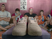 Front view of the pink and white sneakers showing the textured uppers, laces, and patterned soles.