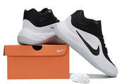 Black and white Nike basketball sneakers shown with an orange shoe box and spare white laces.