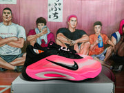 Side view of a pink and black Nike basketball sneaker showing the black Swoosh and layered side construction.