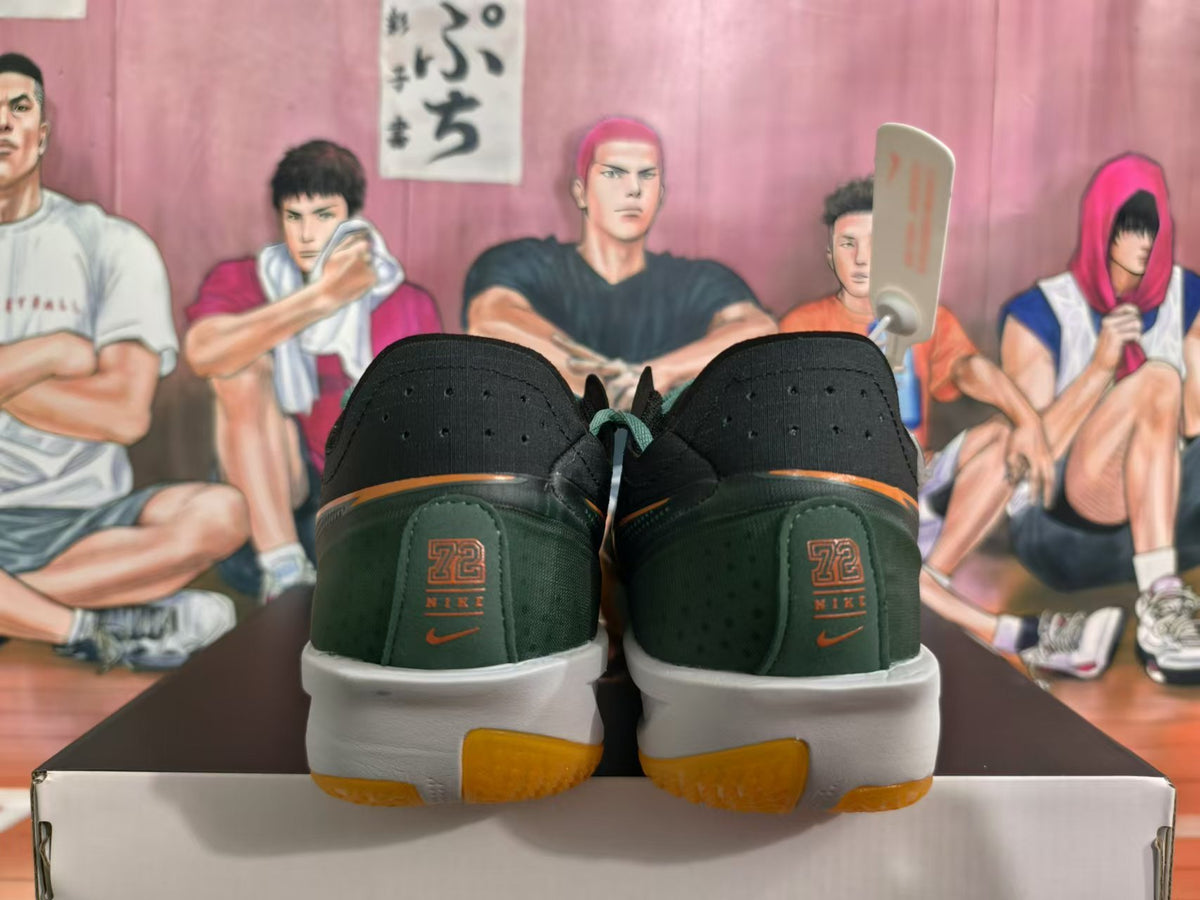 Rear view of black and dark green Nike basketball shoes with orange accents and white midsoles.