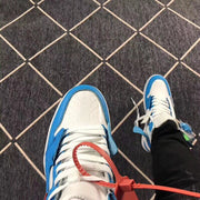 Top view showing the white perforated toe box, blue trim, white laces, and red accent tag.