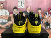Rear view of yellow and black high-top basketball sneakers with embroidered heel logos