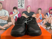 Front view of black Nike sneakers showing the lace-up closure, textured uppers and rounded toe panels.