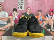Front view of the black lace-up sneaker pair with yellow and green trim.