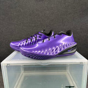Pair of electric purple Nike basketball sneakers displayed on a clear stand, showing black accents and sculpted side detailing.