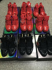 Front view of red and black high-top sneaker pairs arranged in rows on display boxes.