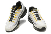 Front view of a pair of Nike Air Max 95 TT sneakers in white, grey, black, and yellow.