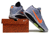 Blue-patterned Nike GT Hustle 3 shoes posed on and beside an orange patterned shoe box.