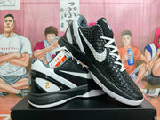 Angled view of black and white Nike Kobe shoes showing the textured upper, Swoosh, and heel details.